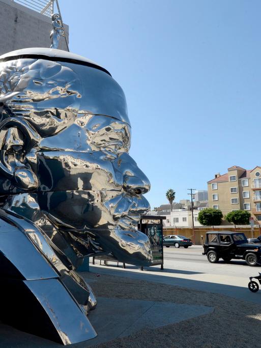 Vor dem ACE Museum in Los Angeles, USA, steht ein riesiger Kopf aus Edelstahl von Lenin, dem russischen kommunistischen Revolutionär. Das Werk der chinesischen Brüder Gao (Zhen und Qiang) trägt den Titel „Miss Mao”.