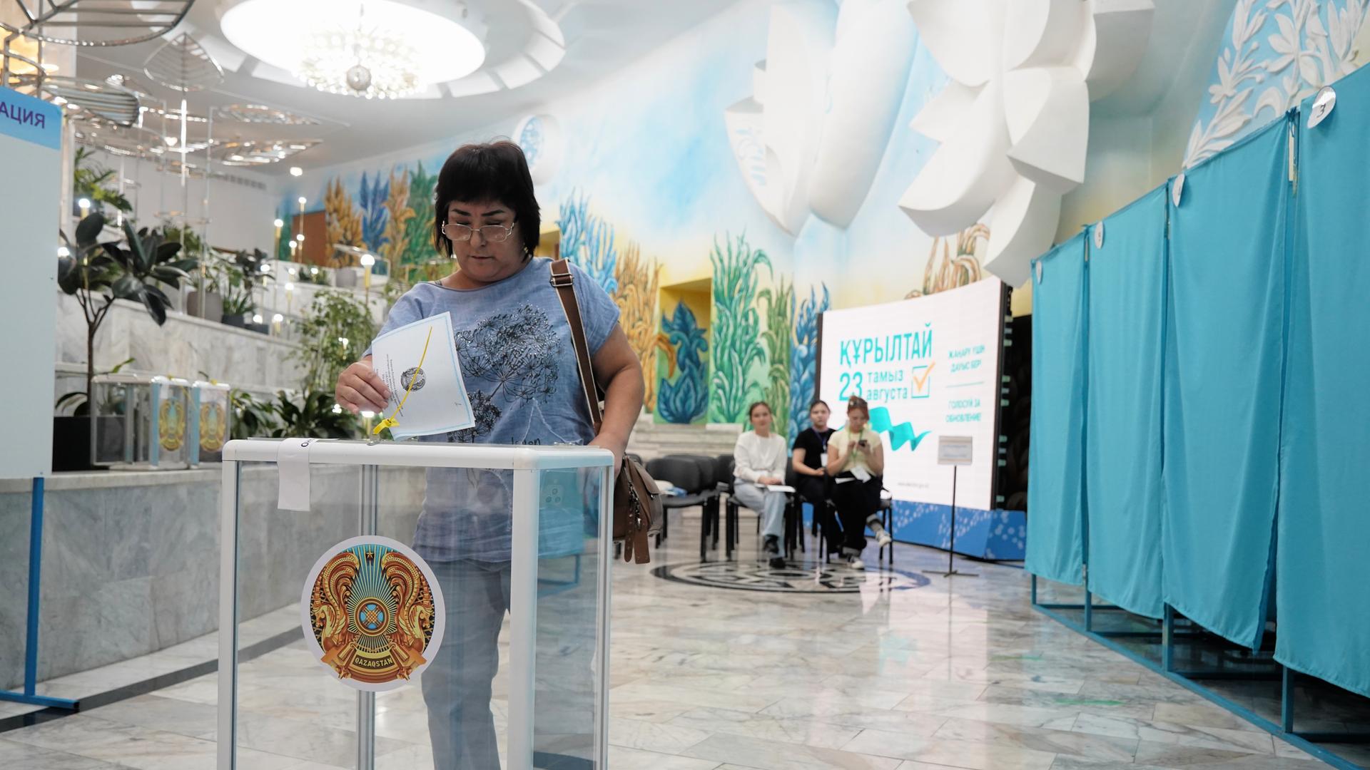 Eine Frau gibt bei vorgezogenen Parlamentswahlen in Almaty, Kasachstan, in einem Wahllokal ihre Stimme ab.