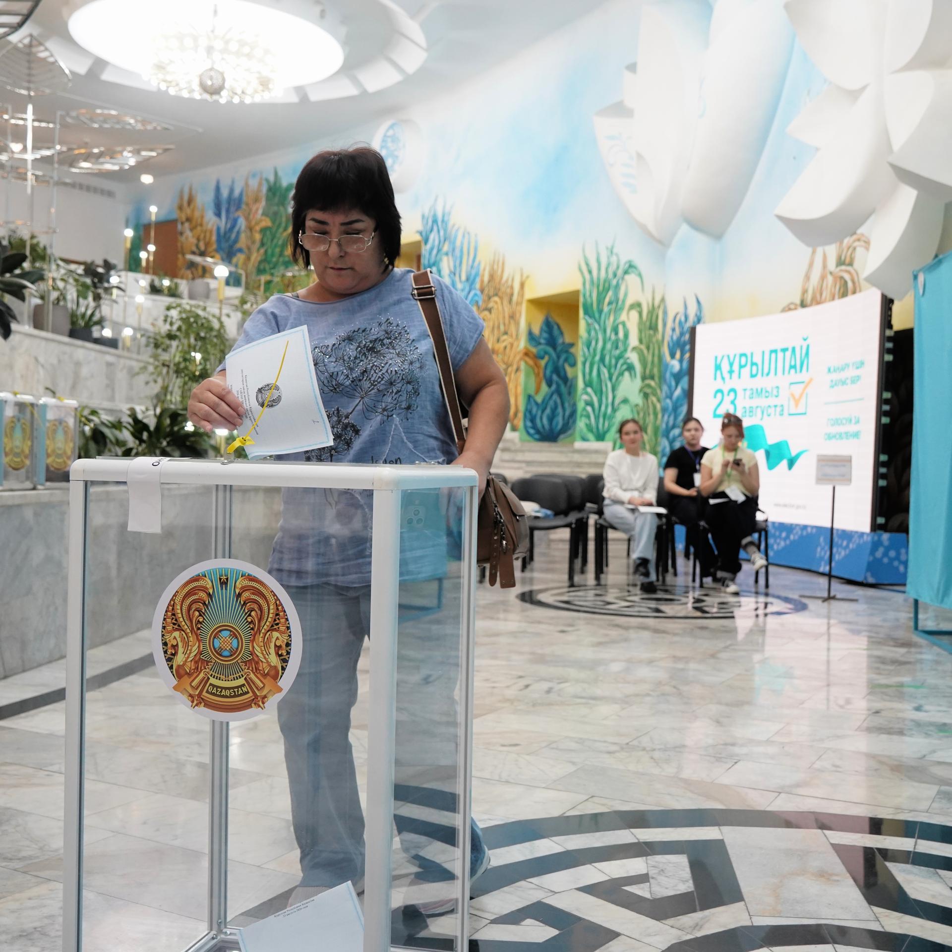 Eine Frau gibt bei vorgezogenen Parlamentswahlen in Almaty, Kasachstan, in einem Wahllokal ihre Stimme ab.