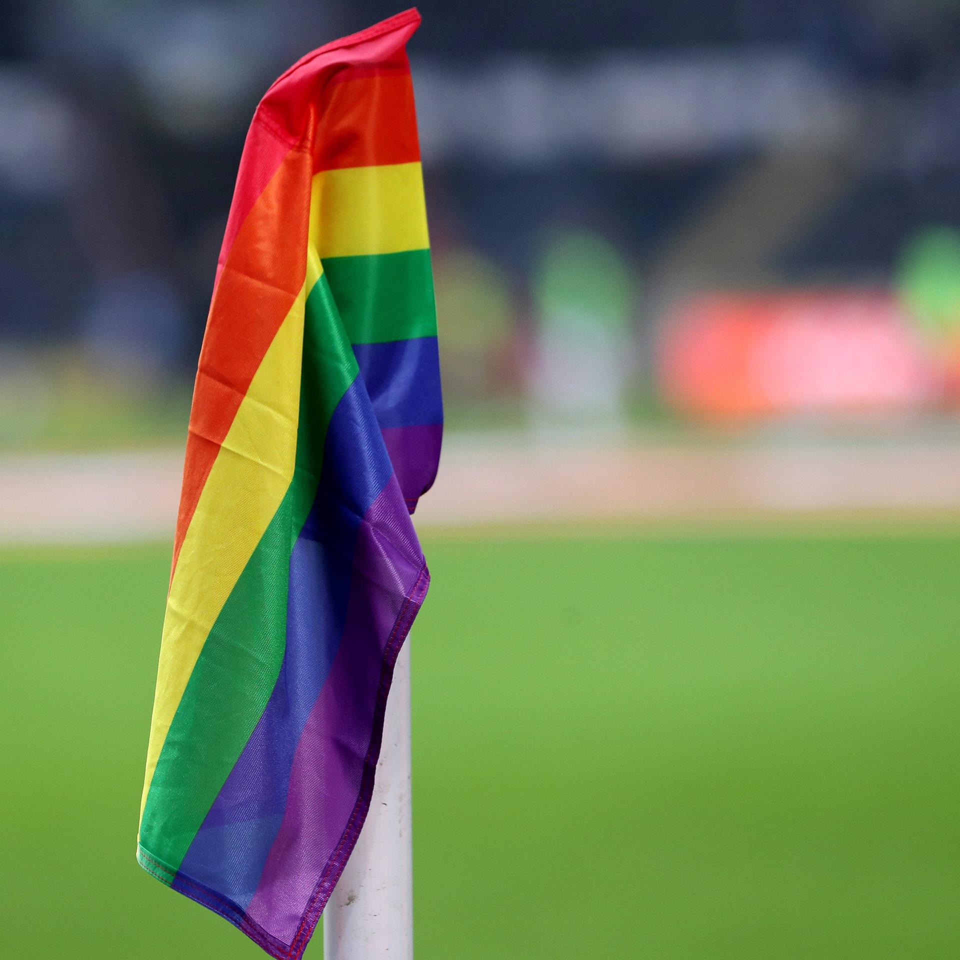 Eine Regenbogenfahne als Eckfahne in einem Fußballstadion.