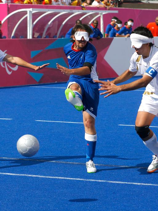 06 September 2012: Paralympics London 2012 - Blindenfussball, 3 Männer mit Augenbinden spielen Fußball
