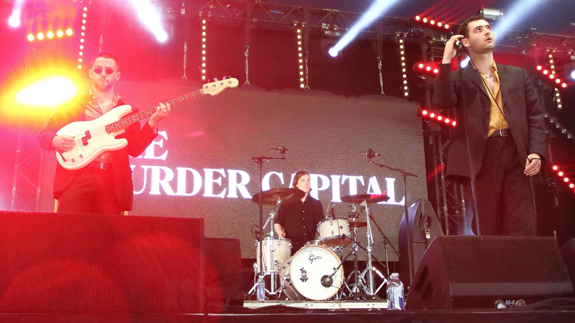 Die irische Band The Murder Capital steht auf einer Bühne, hinter der Band eine Projektion mit dem Namen der Band. Die irische Band The Murder Capital steht auf einer Bühne, hinter der Band eine Projektion mit dem Namen der Band.