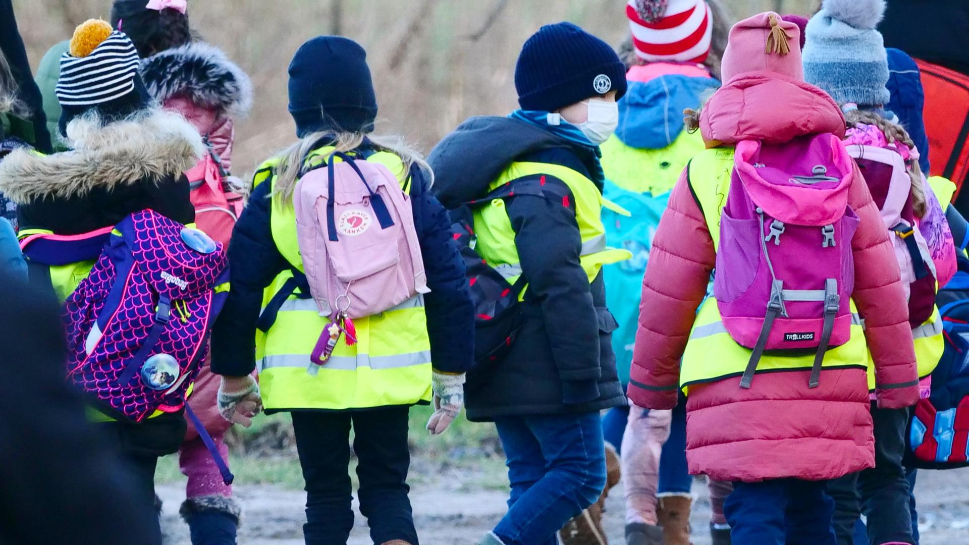 Grundschüler mit Maske und Rucksäcken in Berlin.