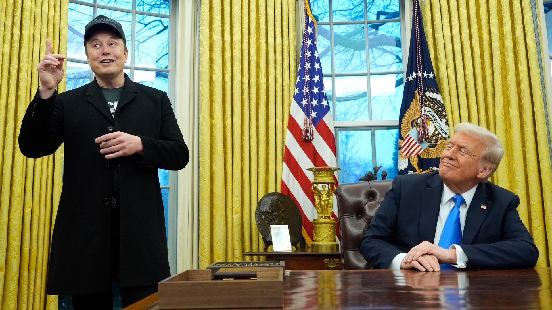 US-Präsident Donald Trump (r) hört zu, als Elon Musk im Oval Office im Weißen Haus spricht. 