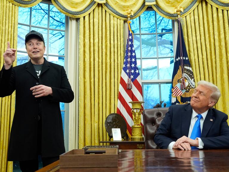 US-Präsident Donald Trump (r) hört zu, als Elon Musk im Oval Office im Weißen Haus spricht. 