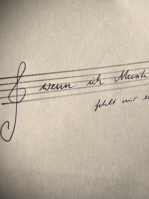 Blick auf eine Notenzeile mit Notenschlüssel, auf dem ein Spruch steht von Walser.