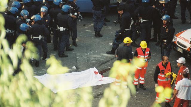 Polizisten stehen um den erschossenen Demonstranten Carlo Giuliani während des G8 Gipfels in Genua, Italien.