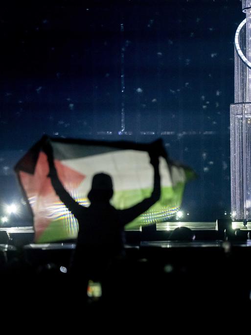 Ein Zuschauer hält eine palästinensische Flagge hoch, während Yuval Raphael bei der Generalprobe für das zweite Halbfinale des Eurovision Song Contests für Israel singt.