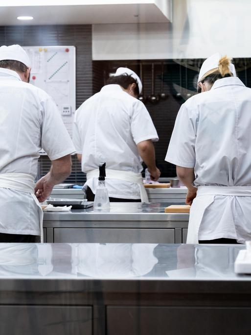 In einer Großküche arbeiten mehrere Angestellte an der Zubereitung von Speisen. In einer Großküche arbeiten mehrere Angestellte an der Zubereitung von Speisen.