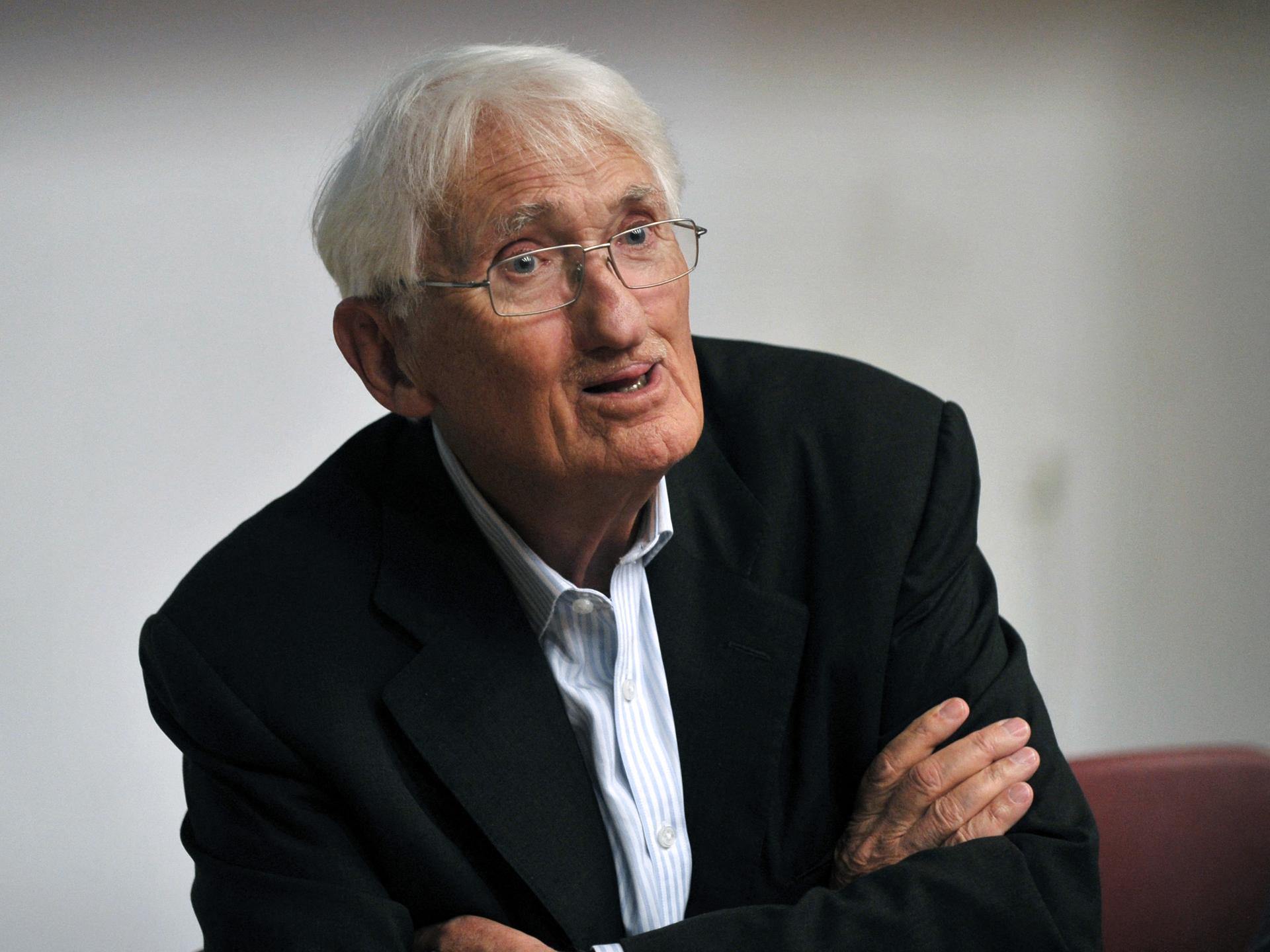 Porträt von Jürgen Habermas. Er hat weißes Haar und trägt ein schwarzes Sakko über einem blau gestreiften Hemd.