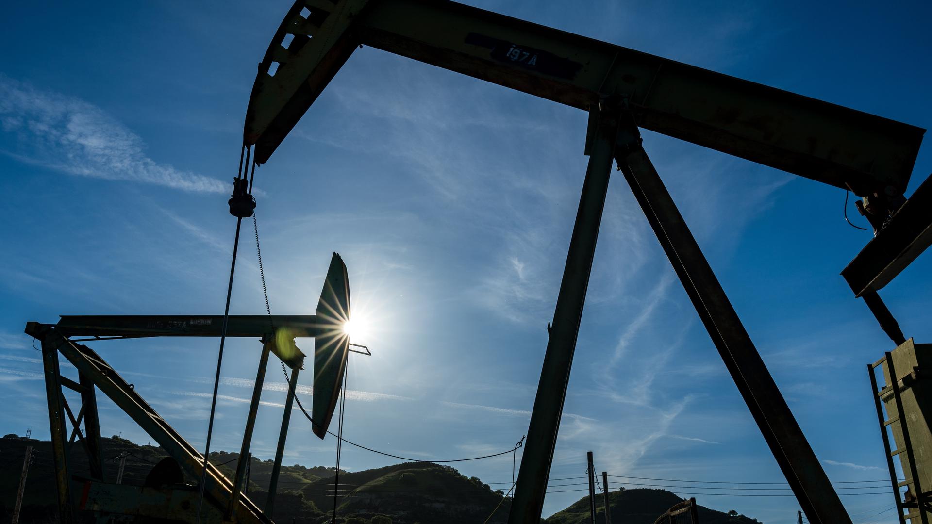 Öl-Pumpen auf dem San Ardo Ölfeld in den USA vor Sonnenschein und klarem Himmel. 