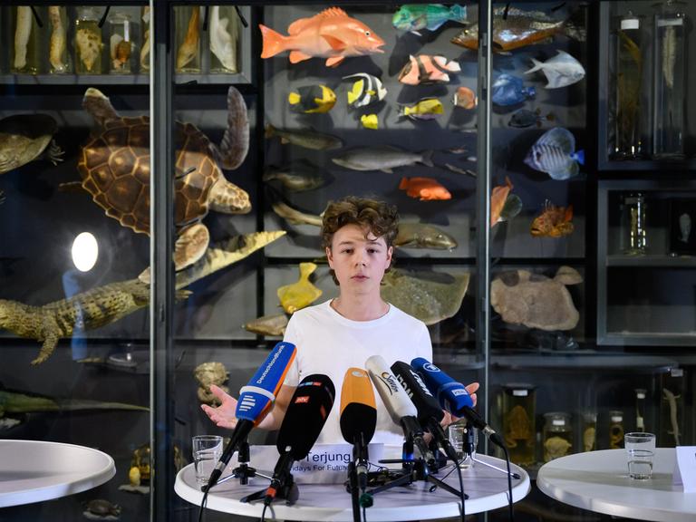 Pit Terjung, Sprecher von Fridays for Future, steht bei einer Pressekonferenz im Museum für Naturkunde vor einem Mikrofon.