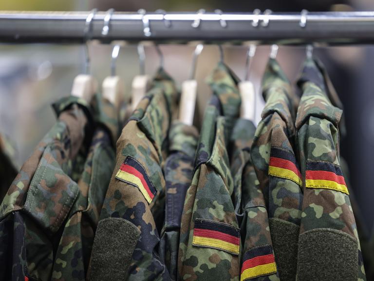 Feldjacken hängen am Stand der Bundeswehr auf einer Kleiderstange
