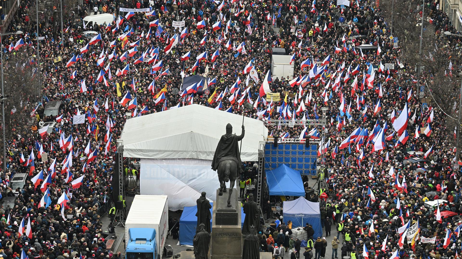 Um eine überdachte Bühne herum stehen tausende Demonstranten und schwenken Flaggen. Um eine überdachte Bühne herum stehen tausende Demonstranten und schwenken Flaggen.