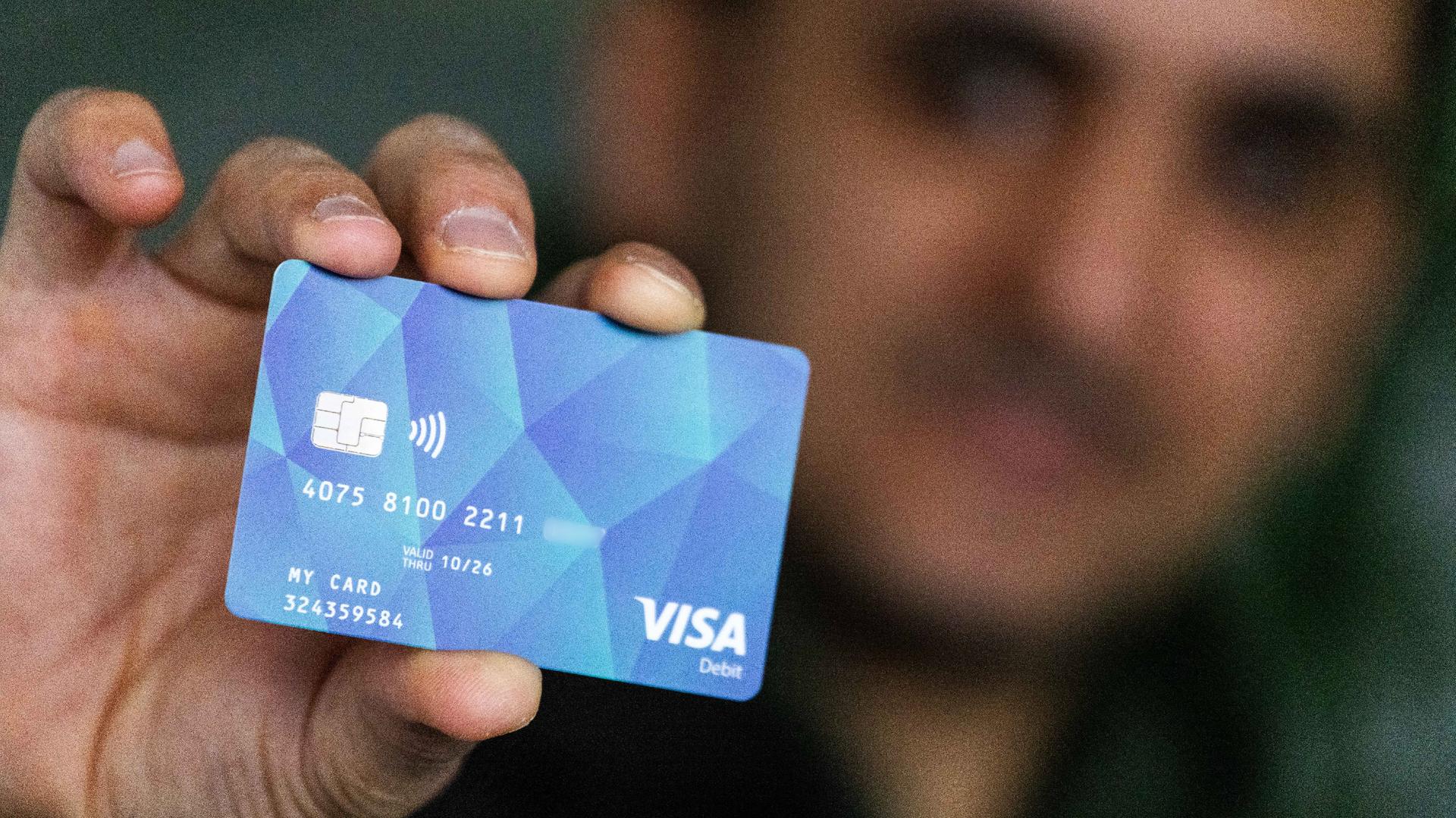 Ein Geflüchteter hält eine Debitcard in der Hand. Der Ortenaukreis zwischen Rhein und Schwarzwald gibt bereits Bezahlkarten für Geflüchtete aus.