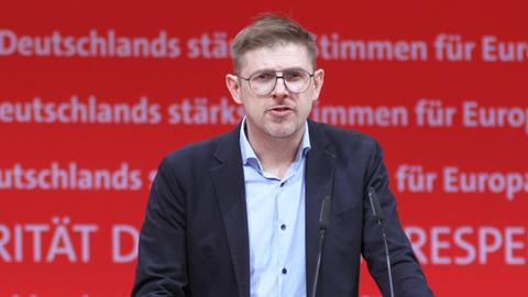 Matthias Ecke steht vor einem Mikrofon. Hinter ihm ein rotes SPD-Banner.