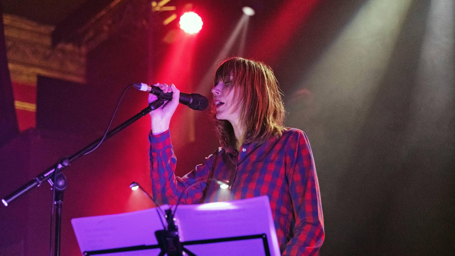 Die britische Sängerin Beth Orton steht am 7. Februar 2018 bei einem Festivalkonzert in Liverpool auf der Bühne. Sie trägt ein rot-blau-kariertes Hemd und singt in ein Mikrofon.