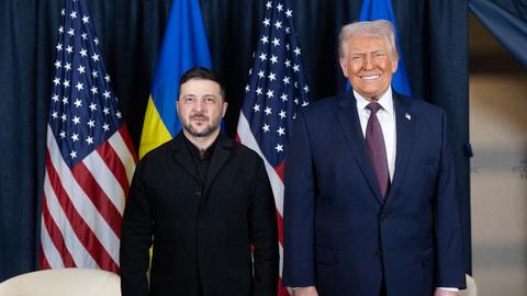 Der ukrainische Präsident Selenskyj steht neben US-Präsident Trump. Im Hintergrund hängen die Fahnen der Ukraine und der Vereinigten Staaten von Amerika.