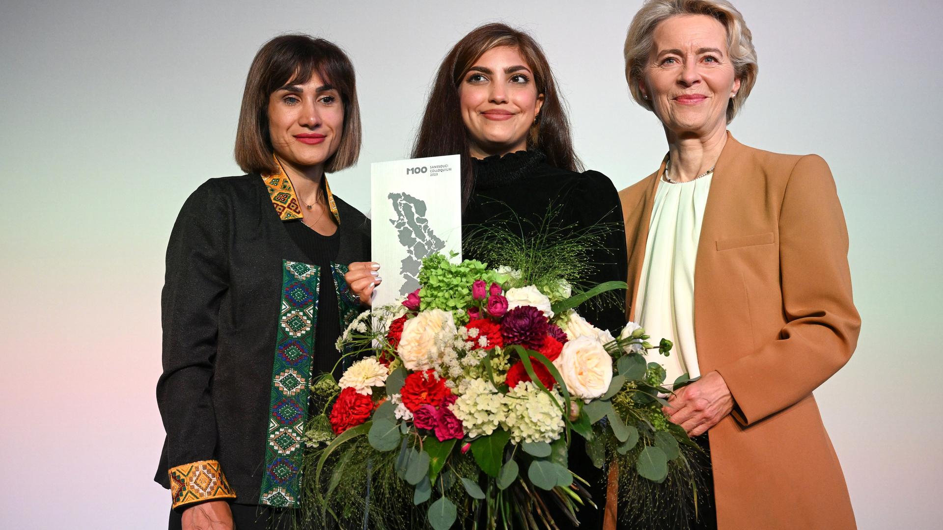 Die iranischen Aktivistinnen Mersedeh Shahinkar, iranische Aktivistin, und Shima Babaei mit der Präsidentin der EU-Kommission, Ursula von der Leyen, bei der Verleihung des M100 Media Awards in Potsdam. 