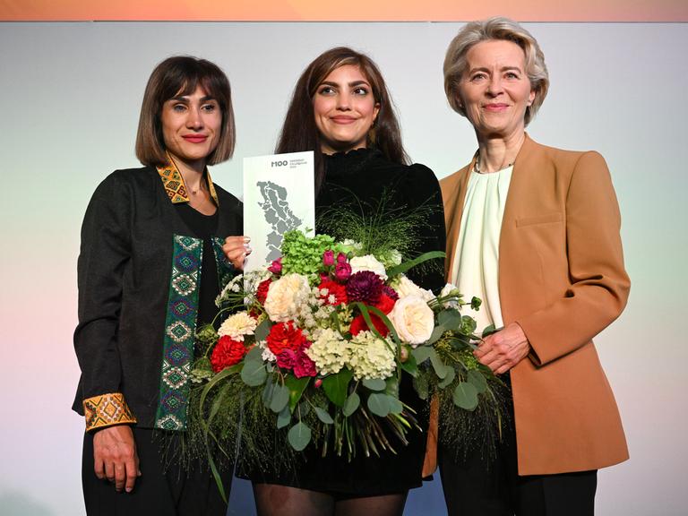 Die iranischen Aktivistinnen Mersedeh Shahinkar, iranische Aktivistin, und Shima Babaei mit der Präsidentin der EU-Kommission, Ursula von der Leyen, bei der Verleihung des M100 Media Awards in Potsdam. 