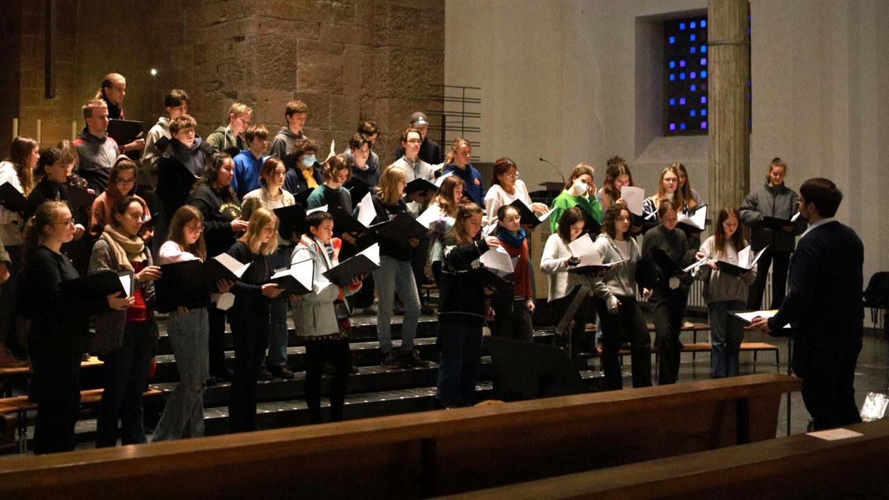 Die Sängerinnen und Sänger des Cantus Juvenum bei einer Probe in einer Kirche.