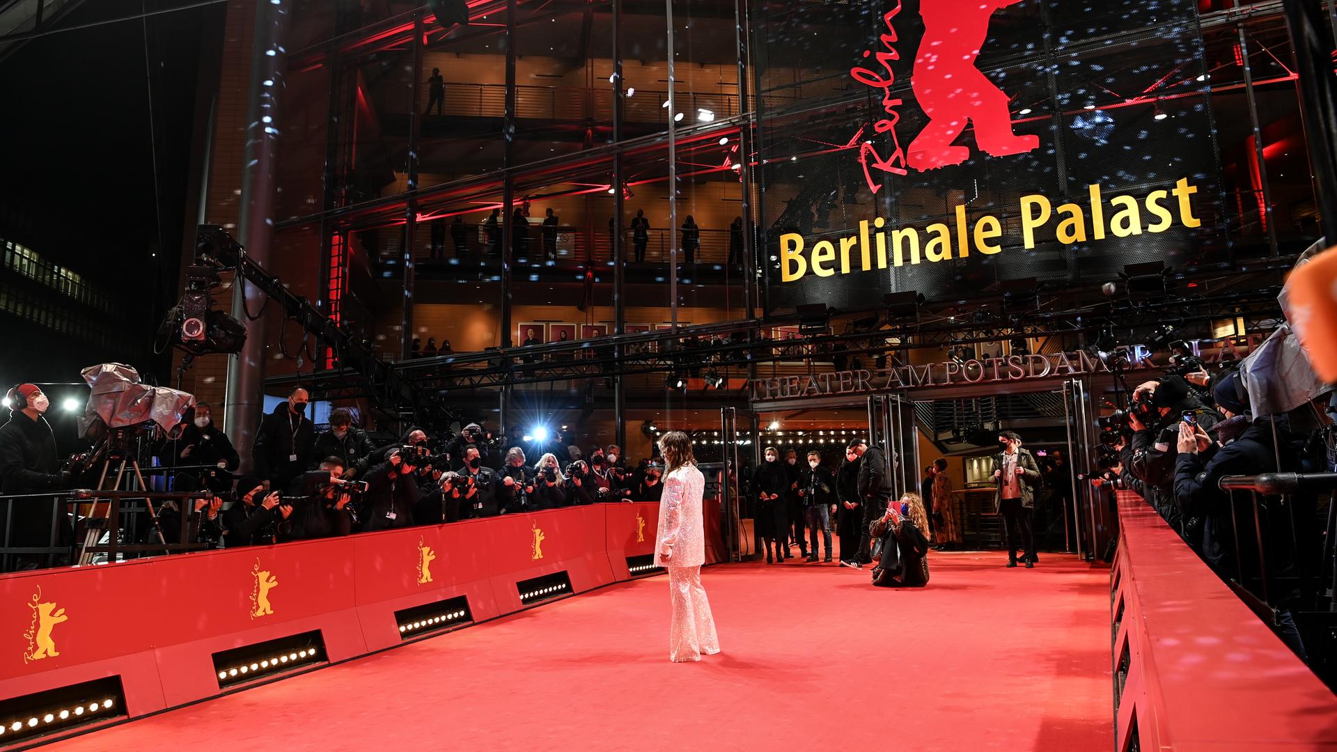 Die Schauspielerin Anne Ratte-Polle steht auf dem roten Teppich der Berlinale und winkt den Fotografen zu. Diese sind weit von ihr entfernt.