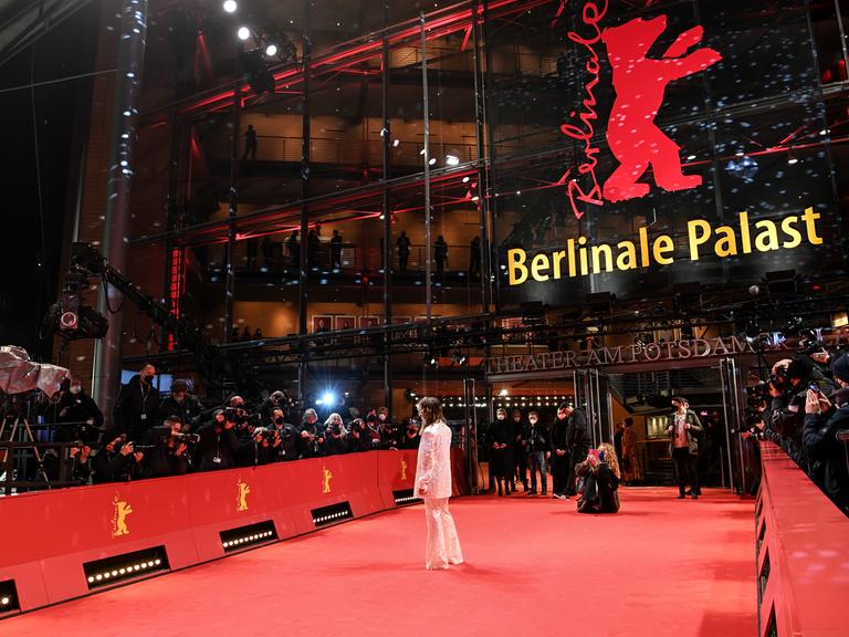 Die Schauspielerin Anne Ratte-Polle steht auf dem roten Teppich der Berlinale und winkt den Fotografen zu. Diese sind weit von ihr entfernt.