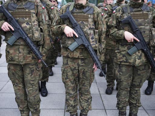 Soldaten der polnischen Armee halten ihre Gewehre während des Appells auf dem Bauch Soldaten der polnischen Armee halten ihre Gewehre während des Appells auf dem Bauch