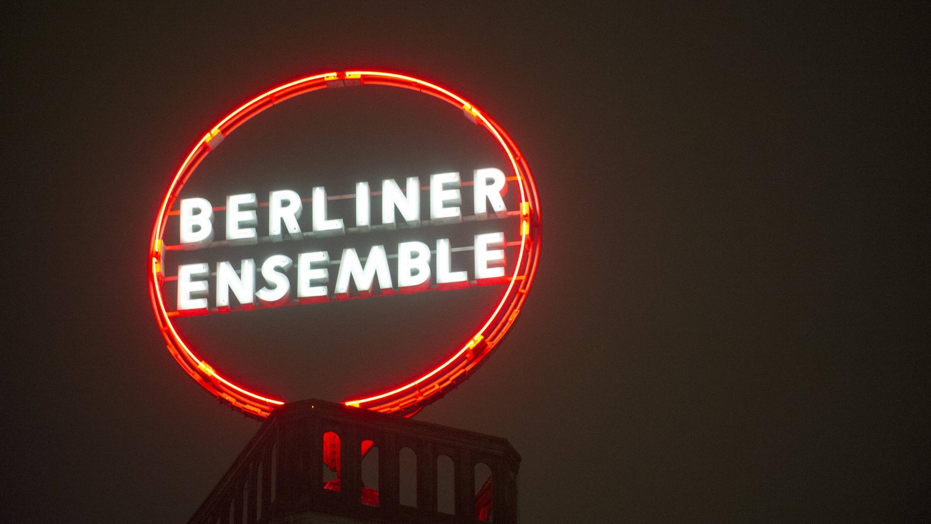 Eine runde Leuchtreklame auf einem Dach zeigt die Aufschrift Berliner Ensemble.