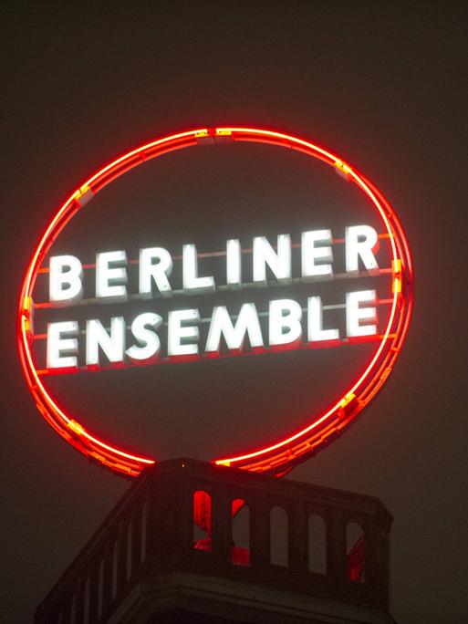 Eine runde Leuchtreklame auf einem Dach zeigt die Aufschrift Berliner Ensemble.