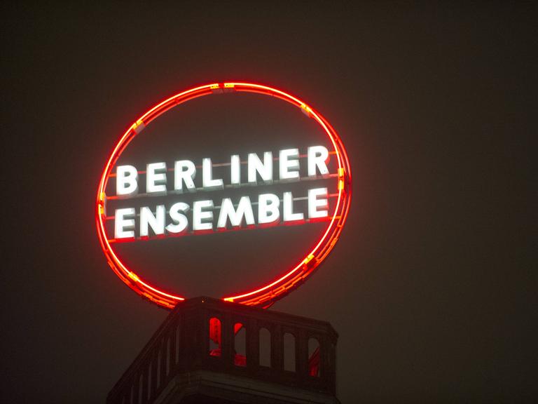 Eine runde Leuchtreklame auf einem Dach zeigt die Aufschrift Berliner Ensemble.