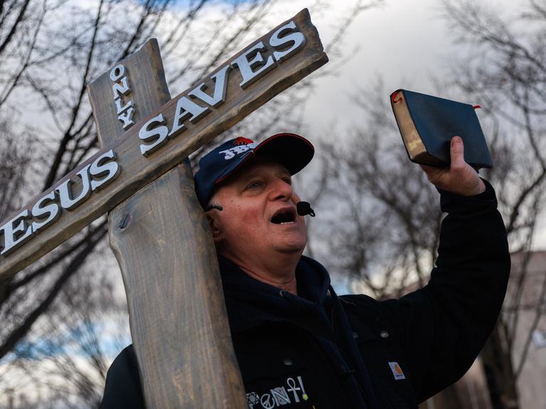 Ein Mann mit Kruzifix und Bibel in der Hand demonstriert in Washington gegen Abtreibung. 