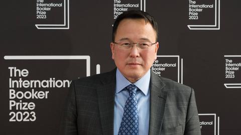 Ein malaysischer Mann mittleren Alters im Anzug mit Brille.