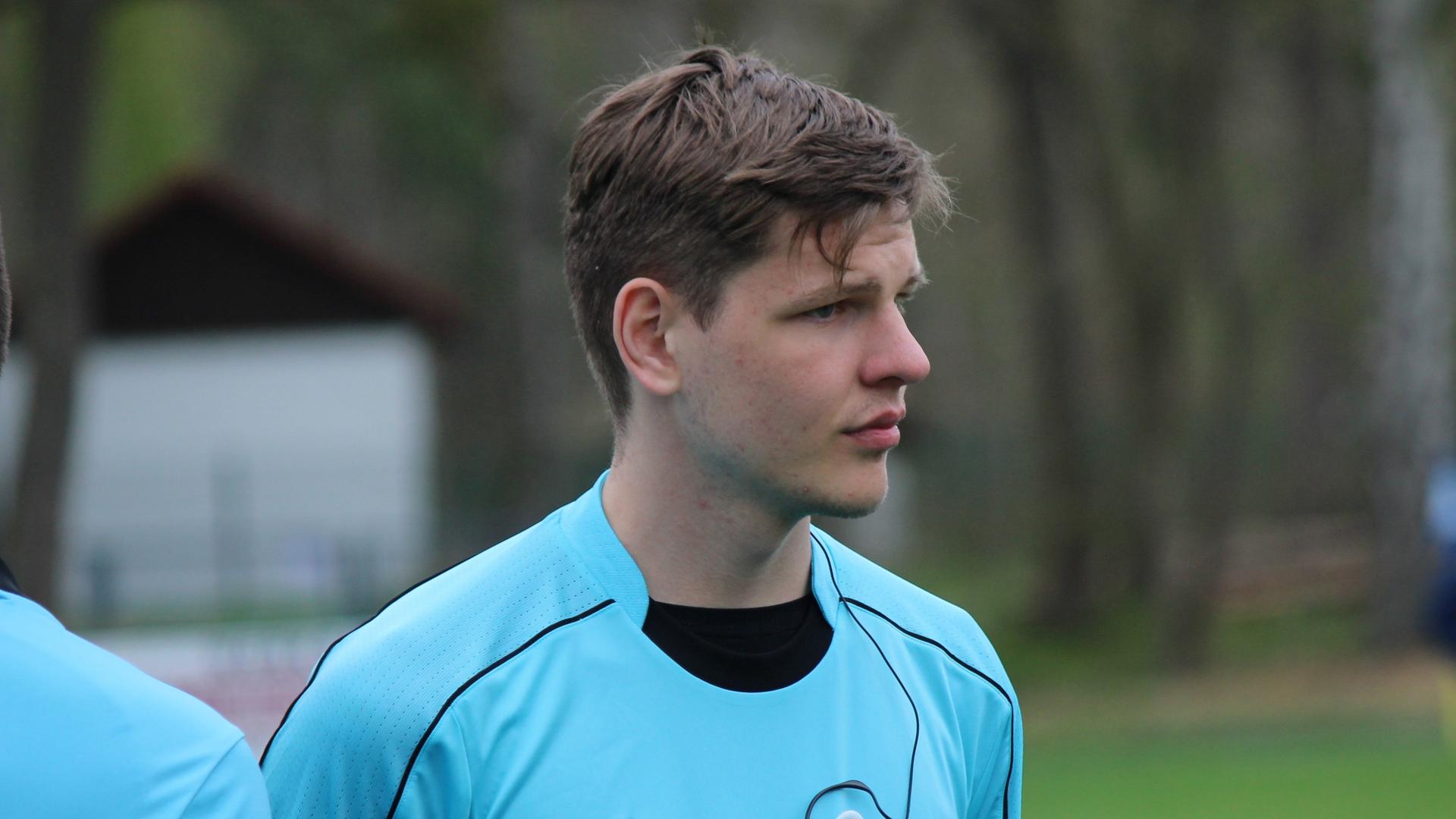 Marius, ein junger Mann, in Schiedsrichter-Trikot