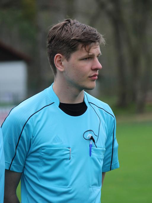 Marius, ein junger Mann, in Schiedsrichter-Trikot