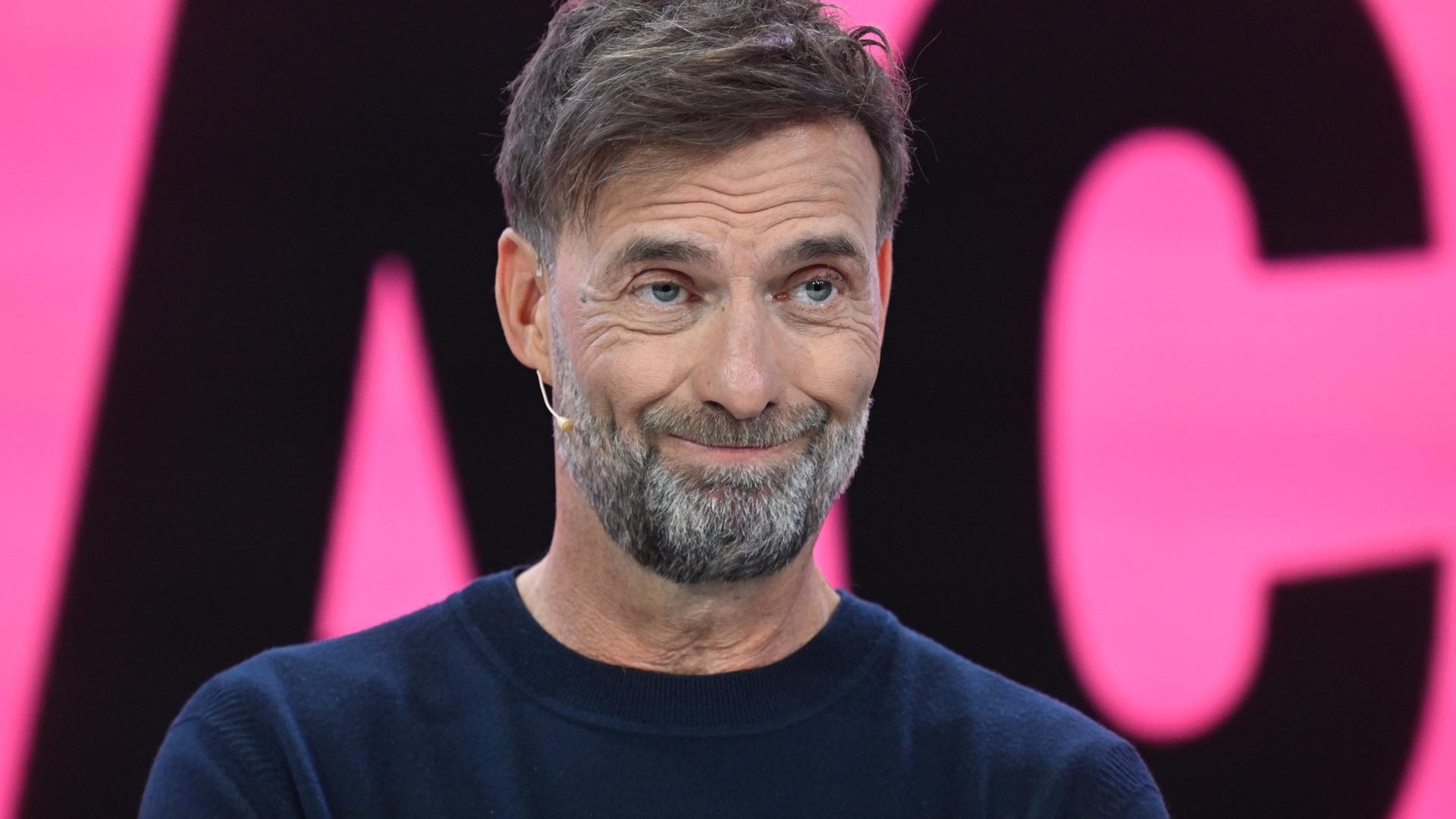 Porträt von Jürgen Klopp vor einem magentafarbenen Hintergrund. Porträt von Jürgen Klopp vor einem magentafarbenen Hintergrund.