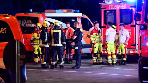 Einsatzkräfte von Polizei und Feuerwehr stehen in Berlin neben Fahrzeugen nach dem Abbruch des Christopher Street Day (CSD). ++
