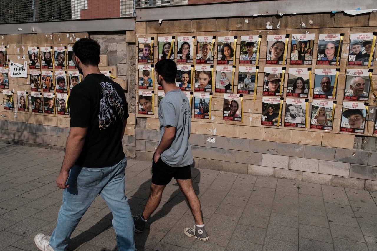 Auf einer Häuserwand in Tel Aviv sind Poster mit den Fotos der Geiseln im Gazastreifen aufgehängt.