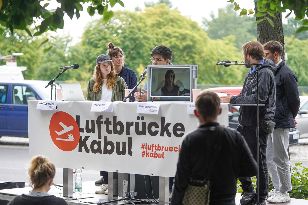 Pressekonferenz vom Aktionsbündnis "Luftbrücke Kabul" vor dem Bundesinnenministerium: Menschen stehen hinter einem Tisch, davor ein Banner mit der Aufschrift "Luftbrücke Kabul".