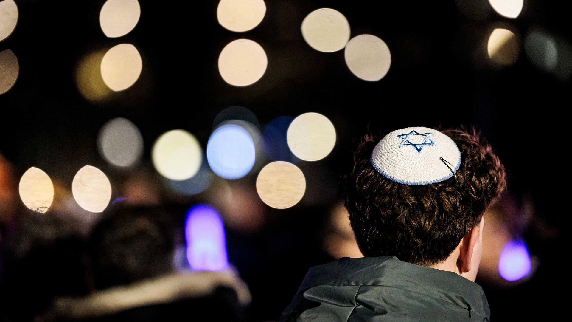 Ein junger Mann trägt eine Kippa auf dem Haar in Amsterdam. Ein junger Mann trägt eine Kippa auf dem Haar in Amsterdam.