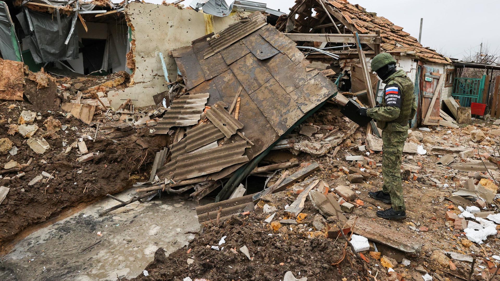 Ein russischer Soldat steht auf einem zerstörten Gebäude.