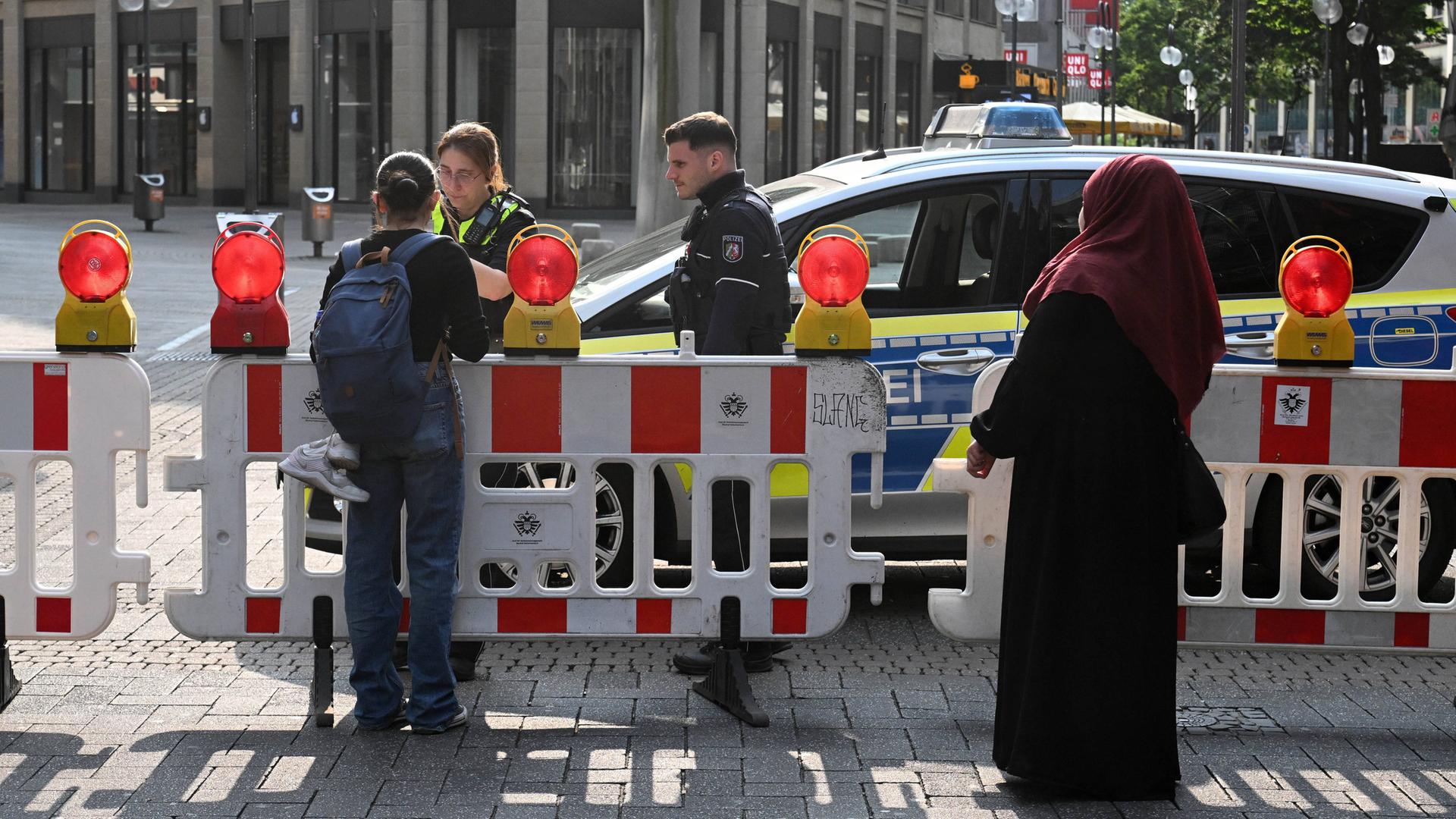 Das Foto zeigt eine abgesperrte Straße in der Innenstadt von Köln. Hinter zwei Absperrgittern parkt ein Polizeiauto. Das Foto zeigt eine abgesperrte Straße in der Innenstadt von Köln. Hinter zwei Absperrgittern parkt ein Polizeiauto.