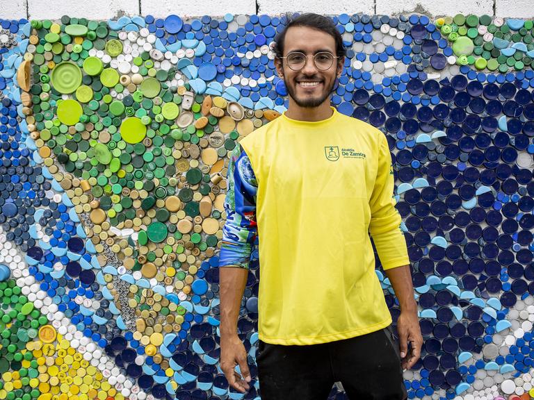 Der Künstler Oscar Olivares posiert für ein Foto vor einem Teil eines 270 Quadratmeter großen Wandgemäldes, das er mit Hilfe der Einwohner in Guatire im Bundesstaat Miranda schafft, um es zum größten Wandgemälde der Welt zu machen.