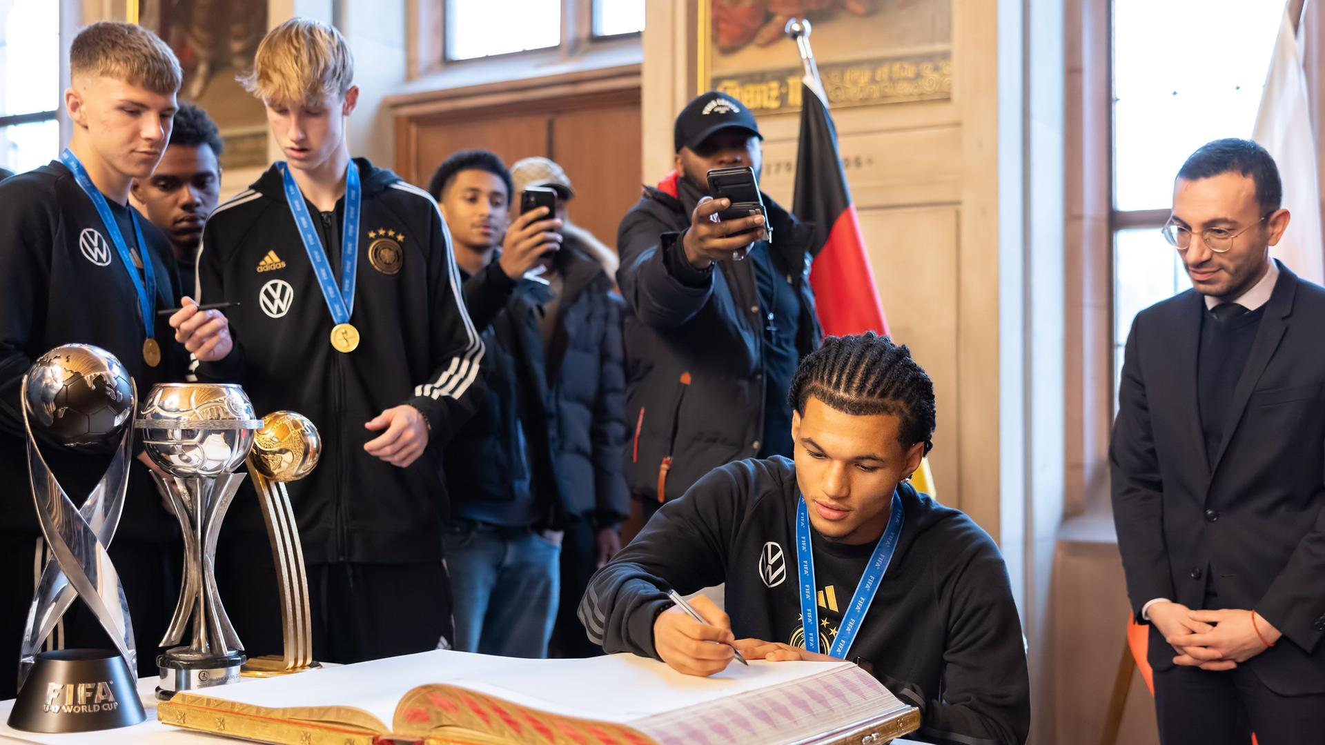 Paris Brunner trägt sich in das Goldene Buch der Stadt Frankfurt ein. Rechts steht Frankfurter Oberbürgermeister Mike Josef (SPD).