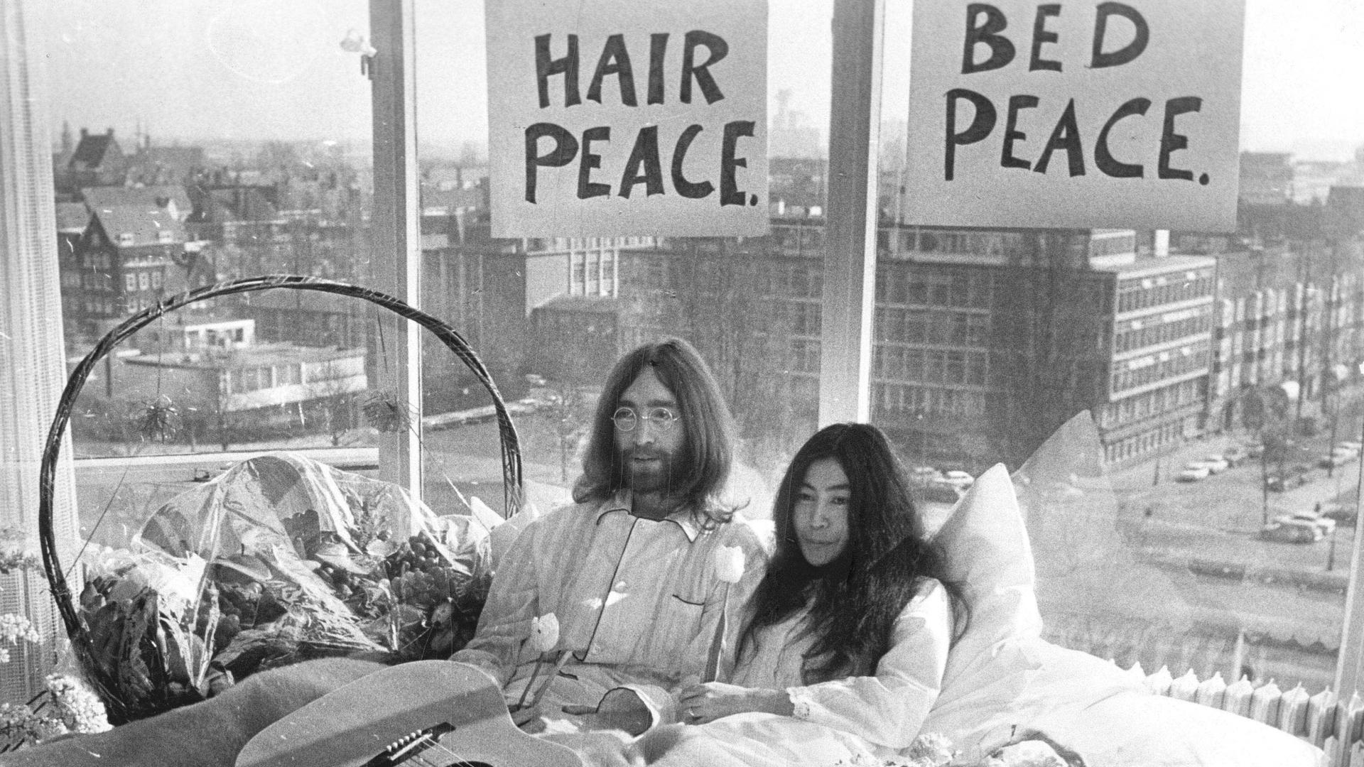 Der Musiker John Lennon von den Beatles und seine Frau Yoko Ono sitzen gemeinsam im Bett während der berühmten „Love-in“-Pressekonferenz in Amsterdam am 25.03.1969.