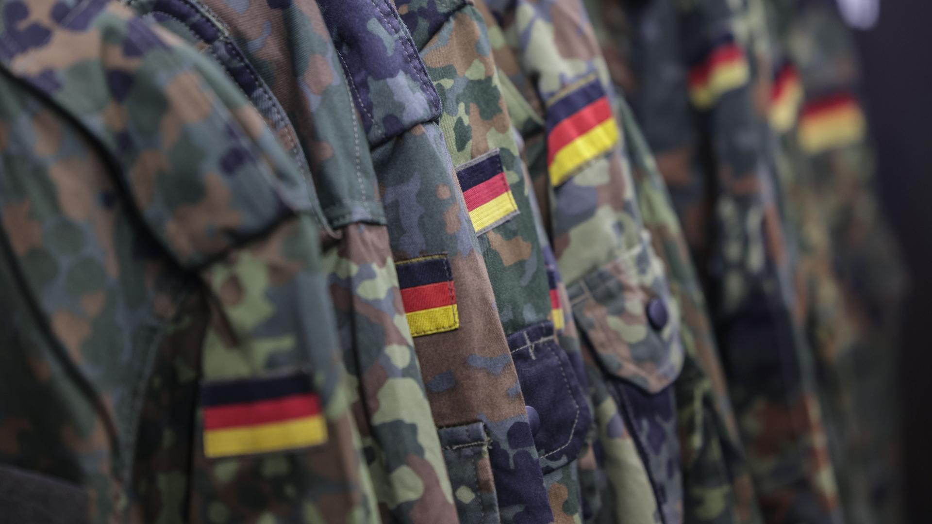 Feldjacken hängen an einem Stand der Bundeswehr auf der Messe Gamescom Feldjacken hängen an einem Stand der Bundeswehr auf der Messe Gamescom