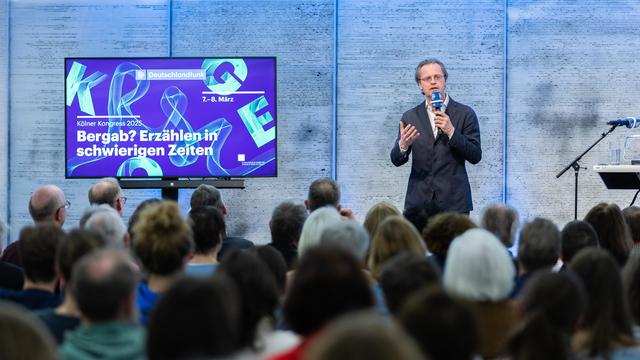 Ein Mann mit Mikrofon im Foyer des Deutschlandfunk Funkhauses während des Kölner Kongresses 2025 in Köln