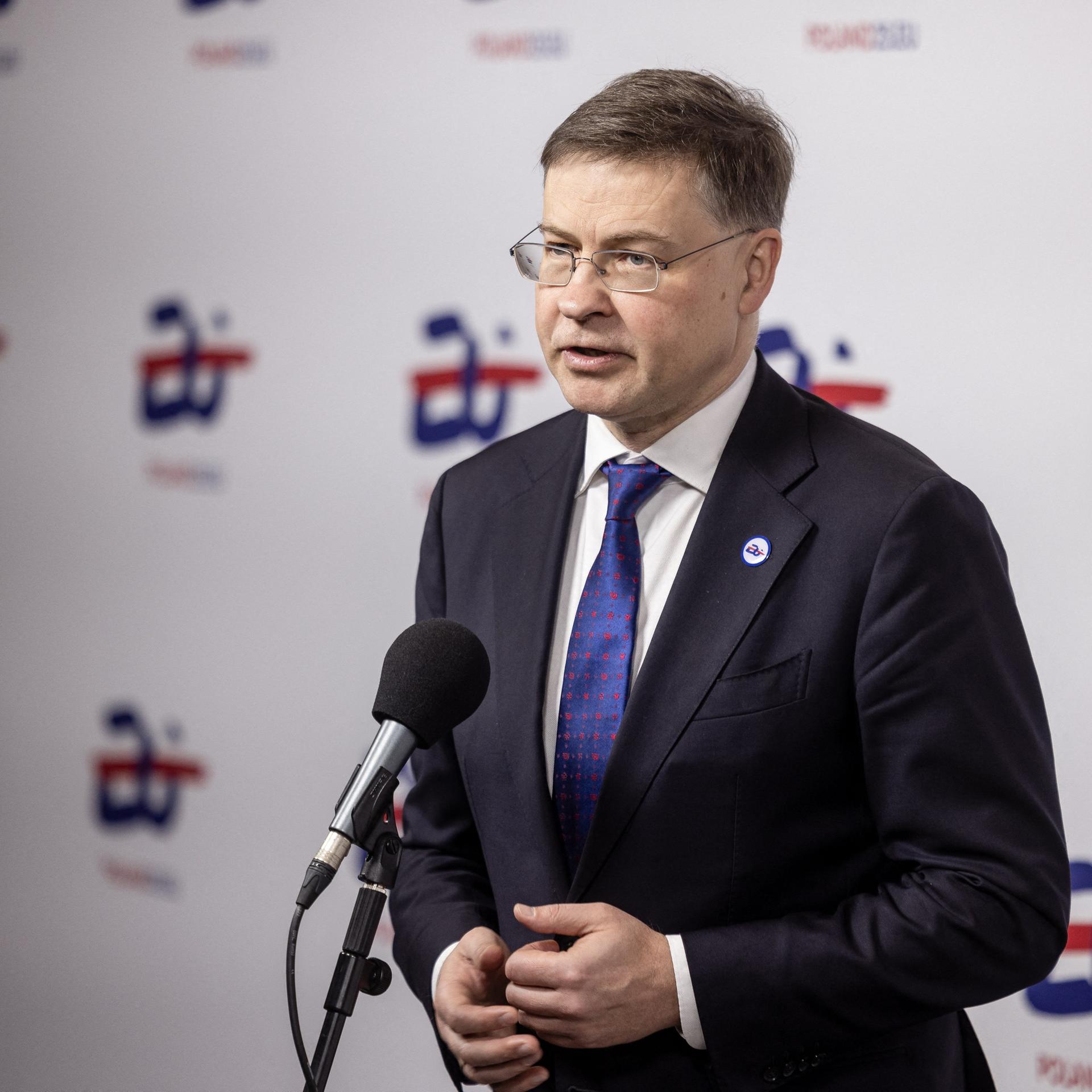 EU-Wirtschaftskommissar Dombrovskis steht hinter einem Mikrofon.