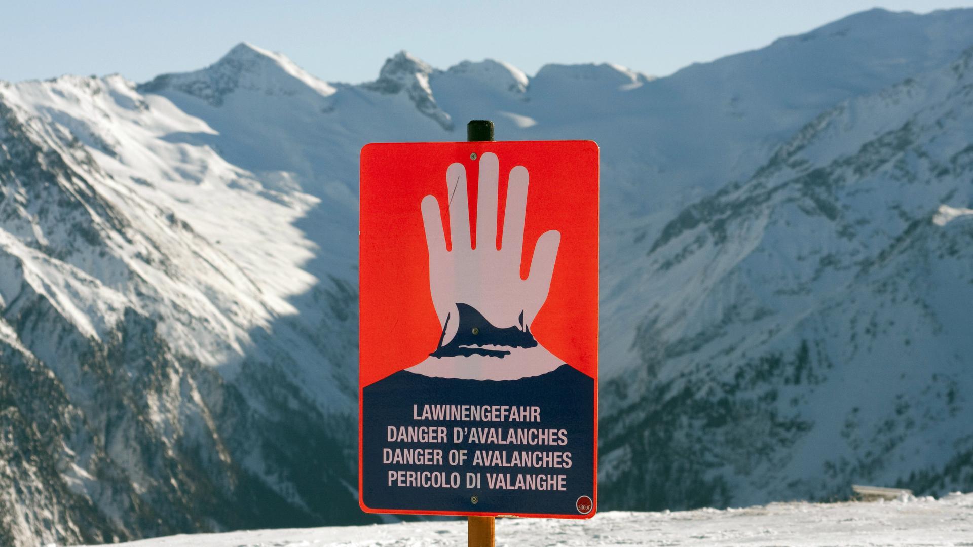 Ein Schild warnt in den Alpen vor Lawinengefahr. Ein Schild warnt in den Alpen vor Lawinengefahr.