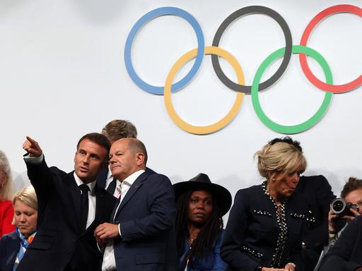 Bundeskanzler Olaf Scholz hält ein  Gespräch mit Frankreichs Staatspräsident Emmanuel Macron auf der Tribüne bei den Olympische Spielen von Paris. 